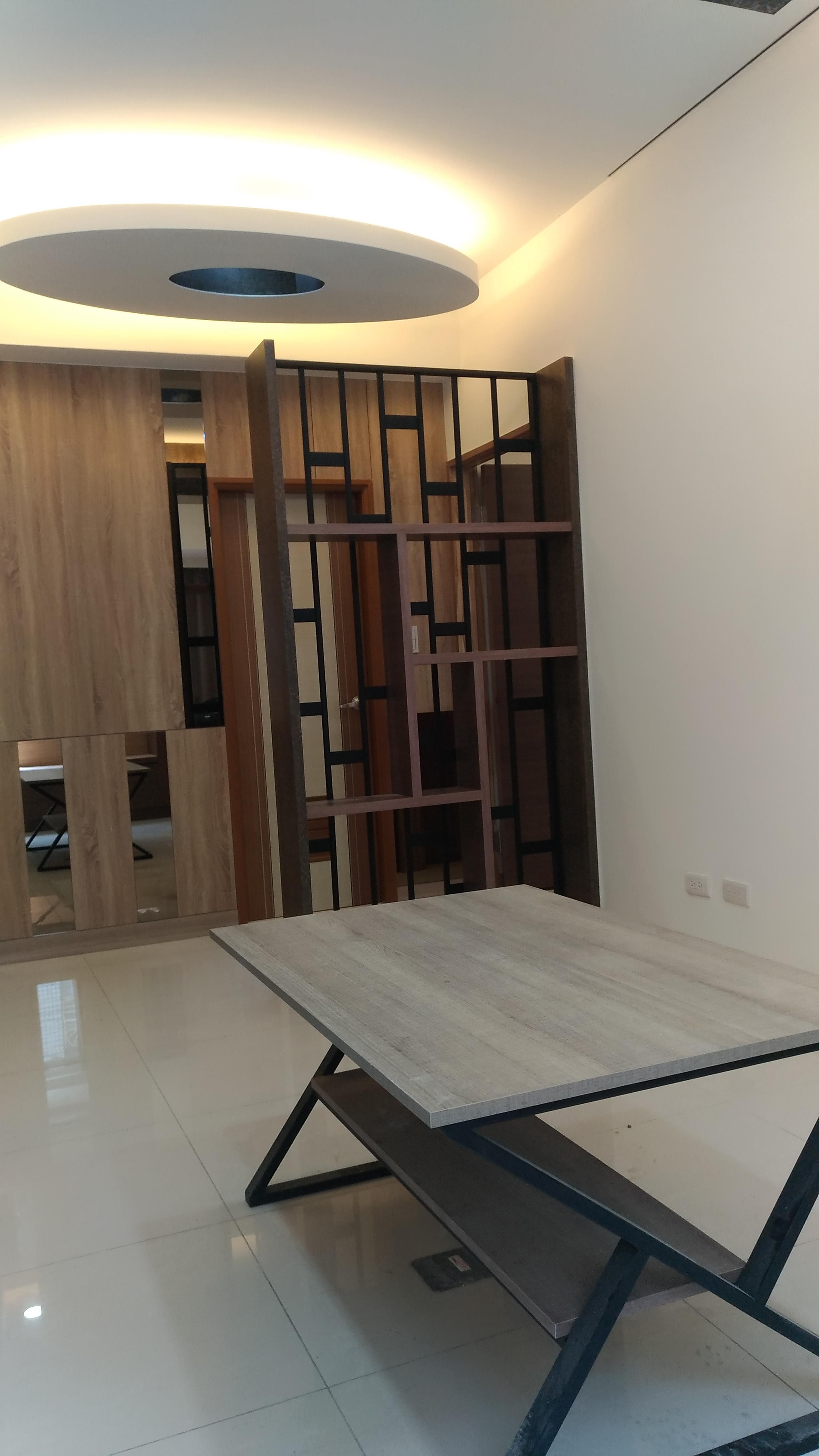 這張照片是展示一個現代風格的餐桌，桌面使用淺色木紋，搭配黑色金屬桌腳，呈現簡約時尚的設計感。